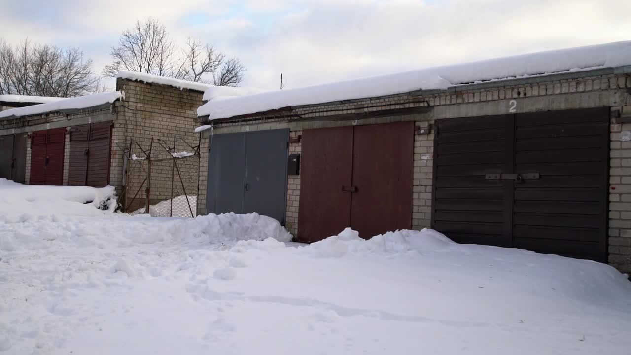 冬天的旧金属车库。雪覆盖的苏维埃车库合作社。没有人视频素材