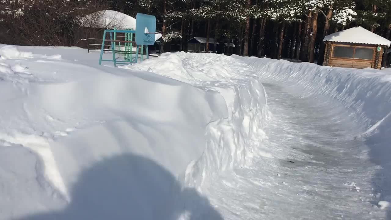 冬天在一个覆盖着雪的木制滑梯上滑雪视频素材