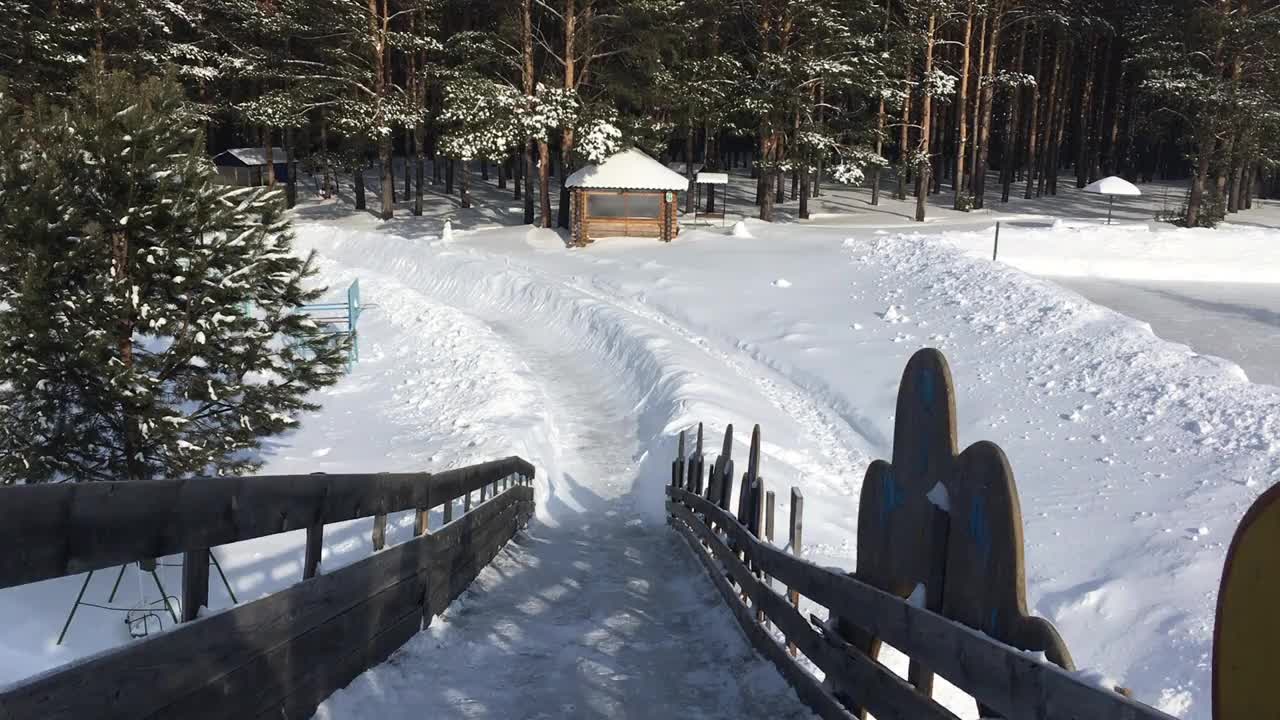 冬天在一个覆盖着雪的木制滑梯上滑雪视频素材