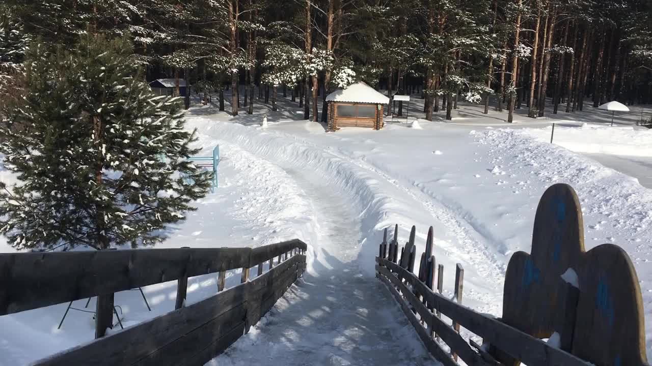 冬天在一个覆盖着雪的木制滑梯上滑雪视频素材