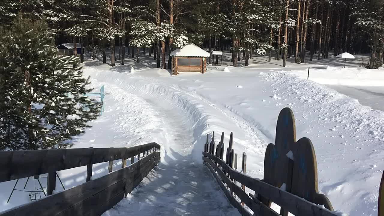 冬天在一个覆盖着雪的木制滑梯上滑雪视频素材