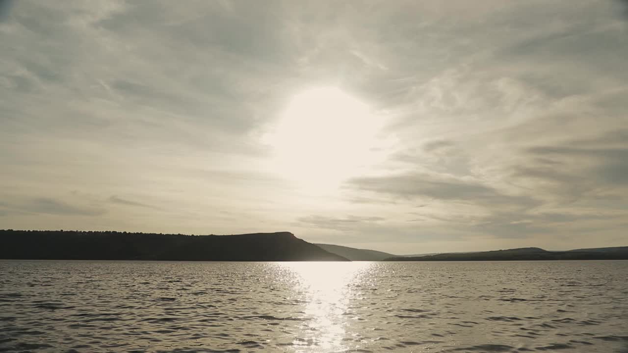 湖上的日落。夏季自然景观太阳下山。背景是山脉和峡谷。平静的海面上太阳的倒影视频素材