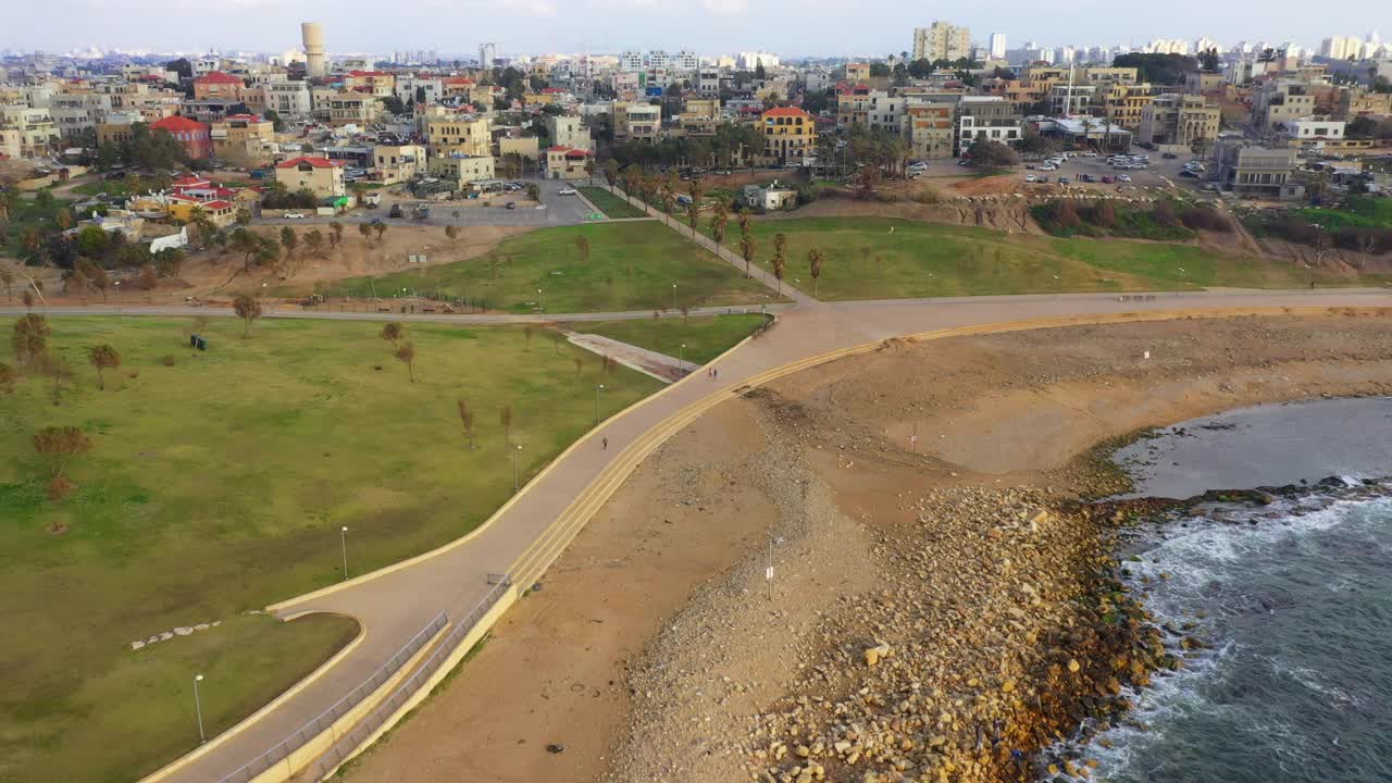 空中拍摄的公园在沿海城市在日落，无人机飞向住宅结构-雅法，以色列视频素材