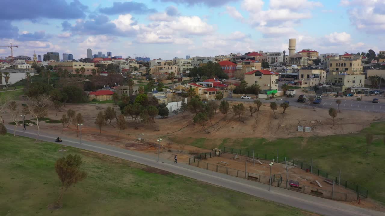 在多云的天空下，空中拍摄的城市住宅，无人机在日落的建筑上向前飞行-雅法，以色列视频素材