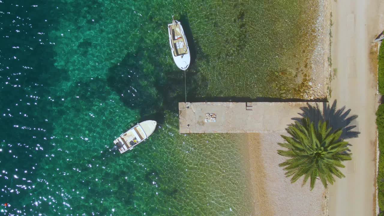 从上到下:在阳光明媚的达尔马提亚，无人机拍摄的是绑在空码头上的船只。视频素材