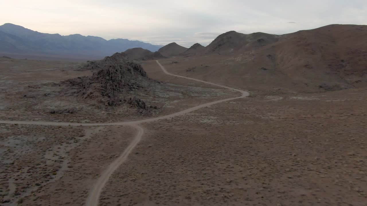 空中平移拍摄著名的阿拉巴马山和山脉对天空，无人机飞过岩石景观与车辆和土路在日落-塞拉，加利福尼亚视频素材