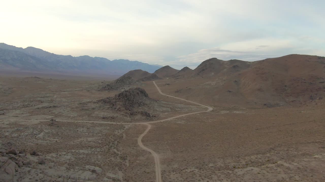 空中平移拍摄的土路在著名的阿拉巴马山对天空，无人机飞在岩石景观在日落-塞拉，加利福尼亚视频素材