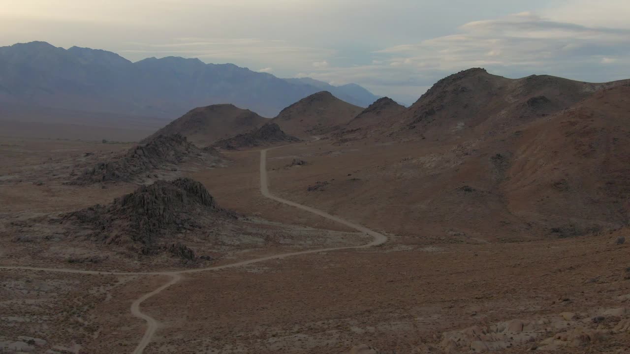 空中缩小拍摄的土路在著名的阿拉巴马山在日落，无人机飞过岩石景观对天空-塞拉，加利福尼亚视频素材