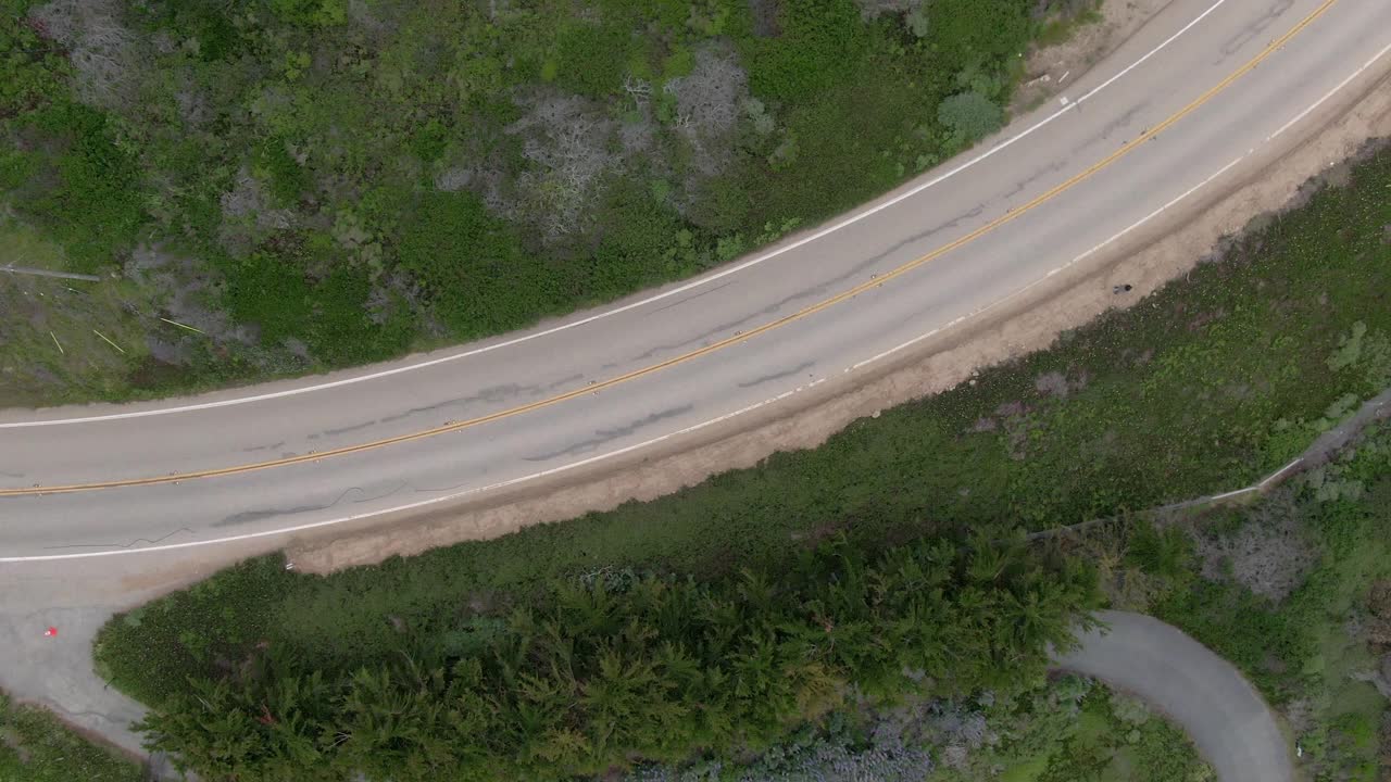 空中顶部平移在绿色植物的道路上的车辆，无人机飞过汽车-大苏尔，加利福尼亚视频素材