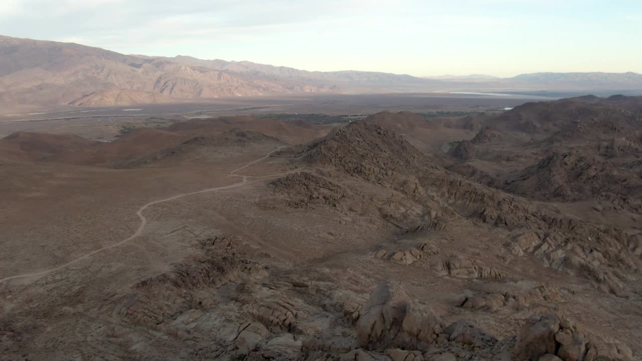 空中拍摄的著名的阿拉巴马山和山脉对天空，无人机在岩石景观与土路在日落-塞拉，加州向前飞行视频素材