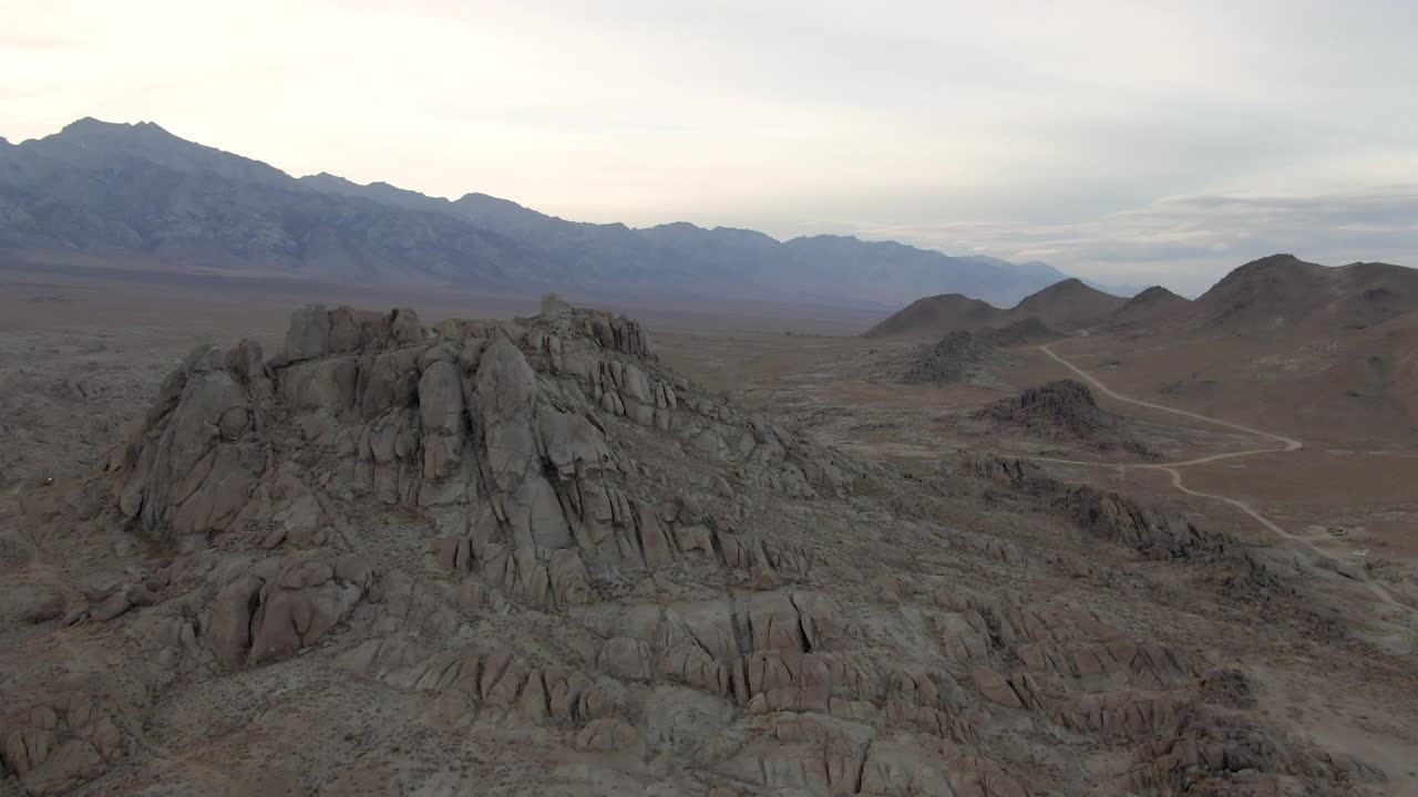 空中平移拍摄的岩石山与土路附近的山脉，无人机向前飞行在日落的著名的阿拉巴马山-塞拉，加利福尼亚视频素材