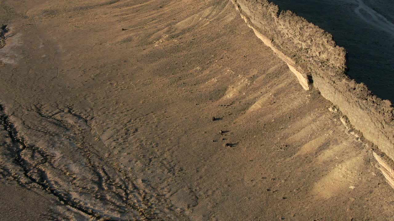 空中倾斜向上拍摄的岩石山在沙漠中对天空，无人机上升向前著名的地标-新墨西哥的船视频素材