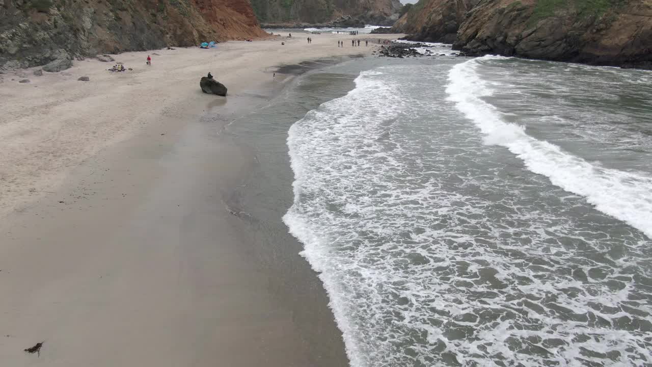 在海滩上海浪溅起的人的航拍，无人机向前飞过Pfeiffer海滩-大苏尔，加州视频素材