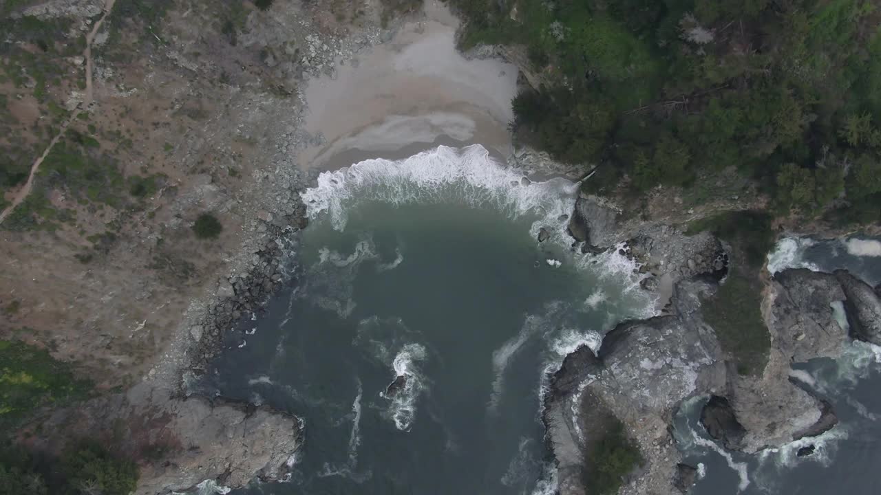 鸟瞰图拍摄的麦克威瀑布溅在海滩上，无人机下降在著名的自然地标-大苏尔，加州视频素材