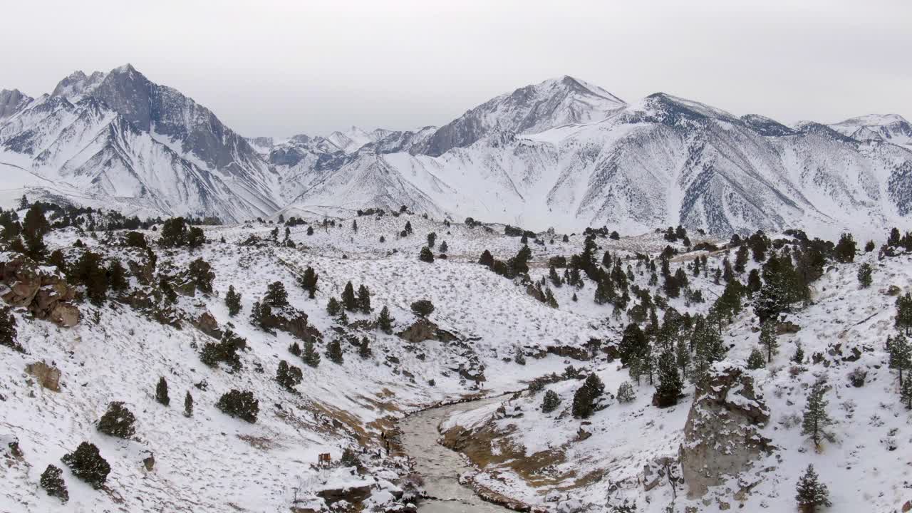 航拍的人在小溪雪山中，无人机向后飞从游客在热溪地质遗址对天空-猛犸湖，加利福尼亚视频素材