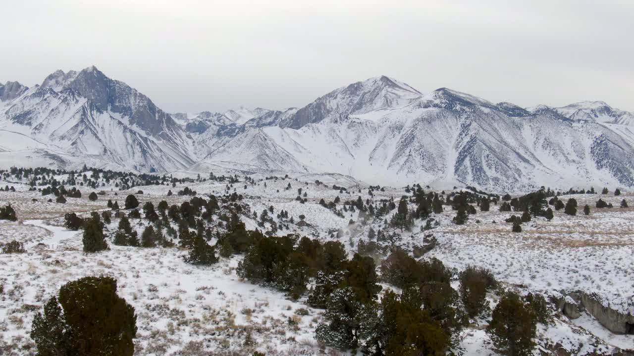 空中拍摄的游客在小溪中雪对天空，无人机下降向前对雪山热溪地质遗址-猛犸湖，加利福尼亚视频素材