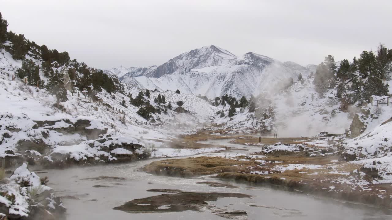 在雪山中释放蒸汽的小溪航拍，无人机向前飞在热的小溪地质地点对天空-猛犸湖，加利福尼亚视频素材