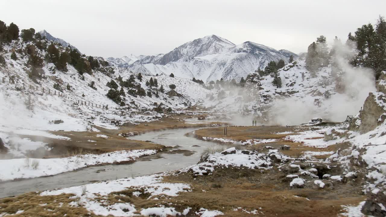 在雪山中小溪的航拍，无人机上升向前的游客徒步在热溪地质遗址-猛犸湖，加利福尼亚视频素材