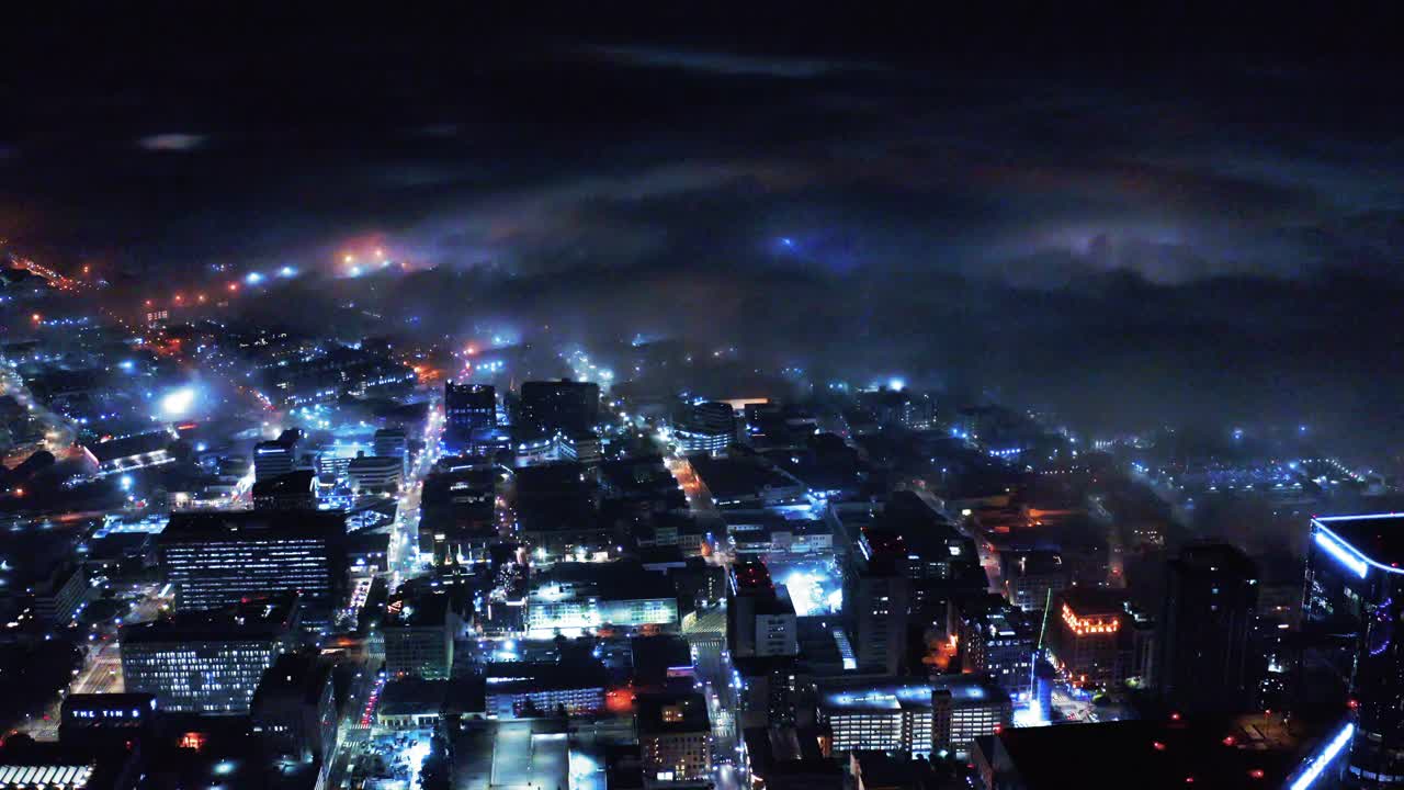 航拍照明现代高楼在城市的夜晚，无人机在大雾天气飞越摩天大楼-洛杉矶，加利福尼亚视频素材