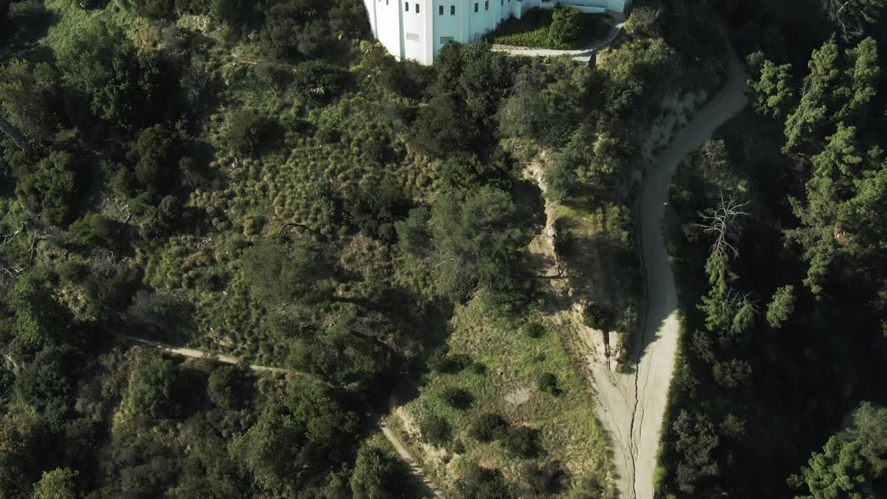 空中倾斜向上拍摄的著名的格里菲斯天文台在山上，无人机向前飞行的地标对天空在晴天-洛杉矶，加利福尼亚视频素材