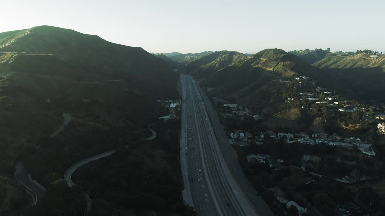 航拍高速公路上的交通由附近著名的盖蒂中心，无人机向前飞行的车辆对天空在日落-洛杉矶，加利福尼亚视频素材