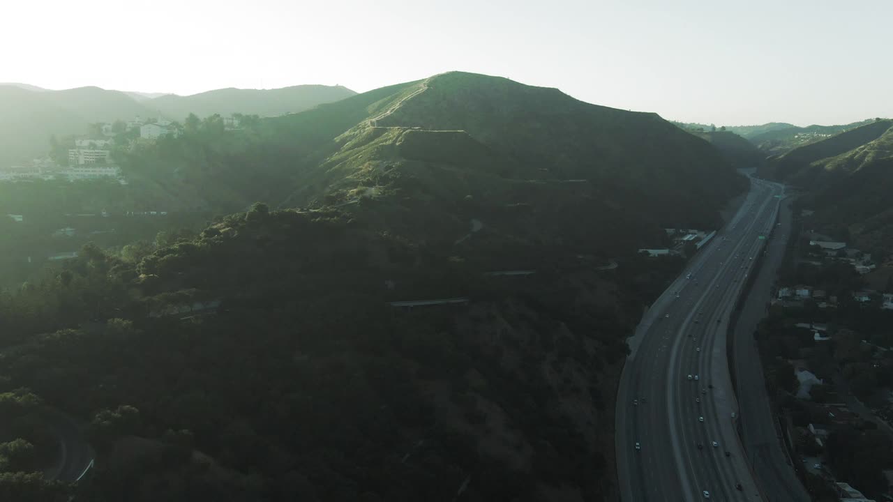 在著名的盖蒂中心附近的高速公路上的交通的空中平移拍摄，无人机向前飞行的车辆对天空在日落-洛杉矶，加利福尼亚视频素材