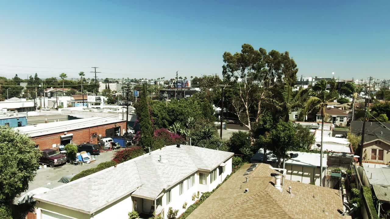 空中拍摄的车辆在街道上的建筑物，无人机向前在城市景观对蓝天在阳光明媚的一天-洛杉矶，加利福尼亚视频素材