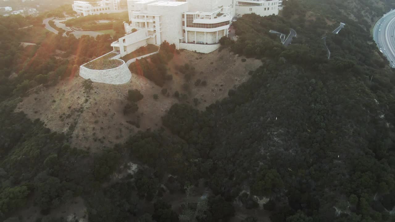 空中倾斜向上拍摄著名的盖蒂中心在山上的天空，无人机飞向博物馆在日落-洛杉矶，加利福尼亚州视频素材