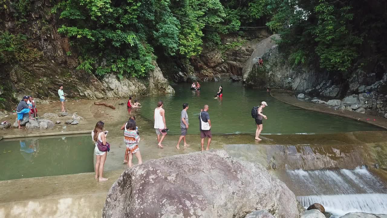 航拍游客享受在森林池塘度假期间，无人机正在向上飞行-卡坦端内斯，菲律宾视频素材