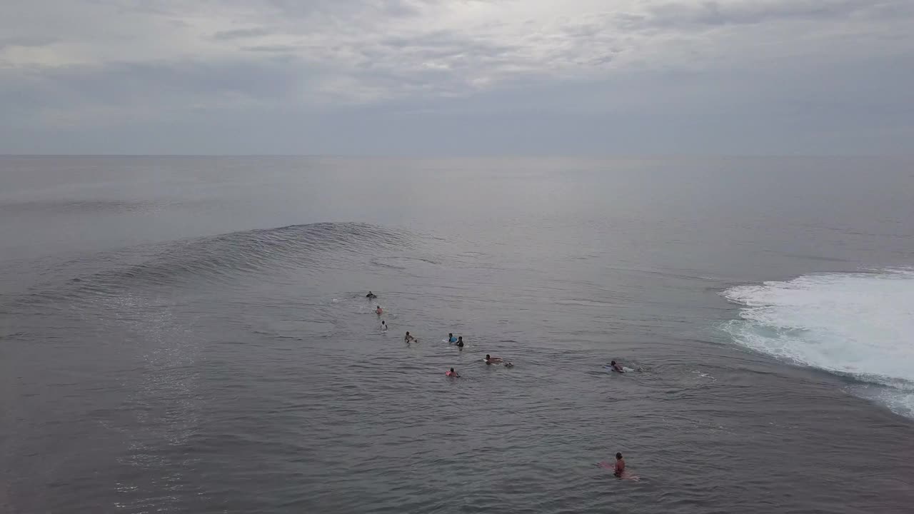 空中平移拍摄的人冲浪在海洋对天空在日落，无人机飞越海洋- Siargao，菲律宾视频素材