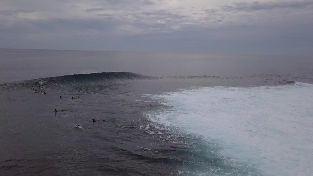 航空拍摄的人冲浪在海洋对天空在日落- Siargao，菲律宾视频素材