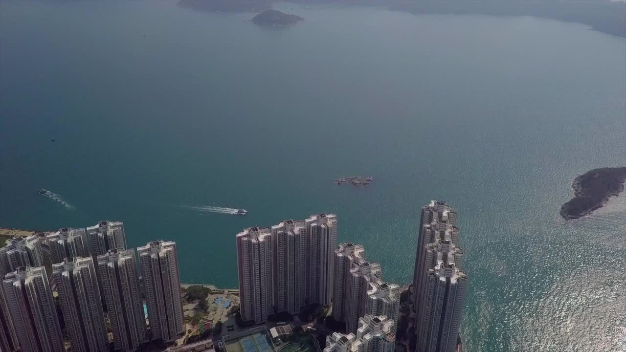 空中倾斜向下拍摄的城市与船在晴天，无人机飞过现代摩天大楼-香港，中国视频素材