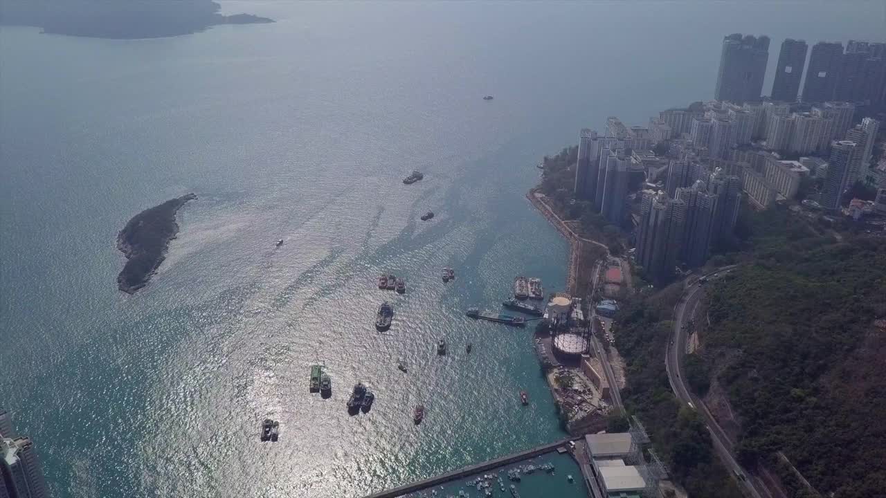 在阳光明媚的日子，无人机在现代摩天大楼上空的海上城市的空中摇摄-香港，中国视频素材