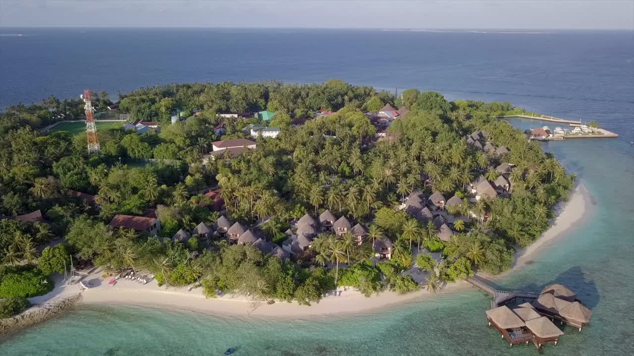 空中拍摄的岛屿与绿色的树木对天空，无人机向后上升在晴朗的一天-班多斯，马尔代夫视频素材