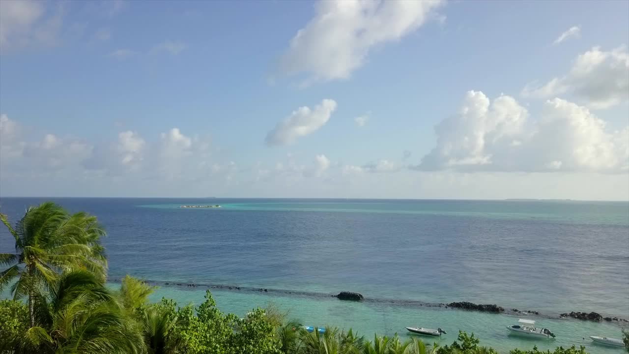 航拍美丽的海景在晴朗的一天，无人机飞向岛屿在海上-南马累环礁，马尔代夫视频素材