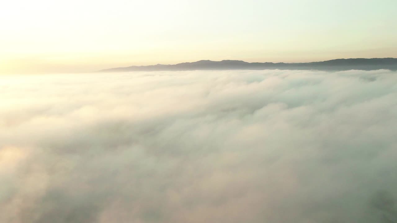 空中拍摄的云彩景观附近的山对天空在日落，无人机飞向山脉-洛杉矶，加利福尼亚视频素材