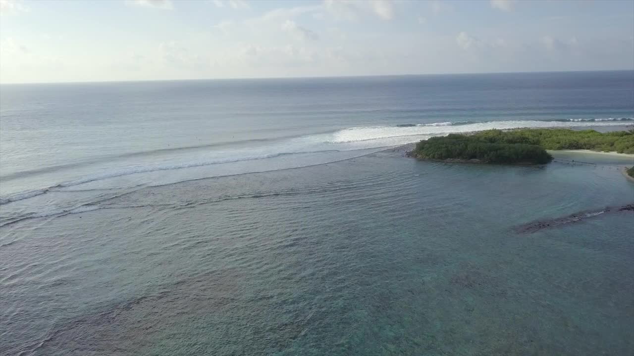 海浪在海上溅起浪花的空中拍摄，无人机向前飞向在海上的冲浪者-南马累环礁，马尔代夫视频素材