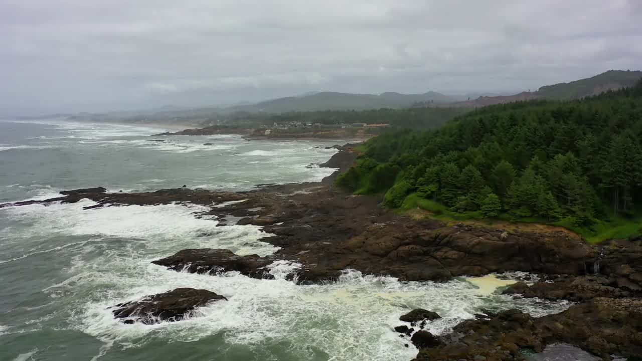 航拍的海浪溅在海岸对多云的天空-曼萨尼塔，俄勒冈州视频素材