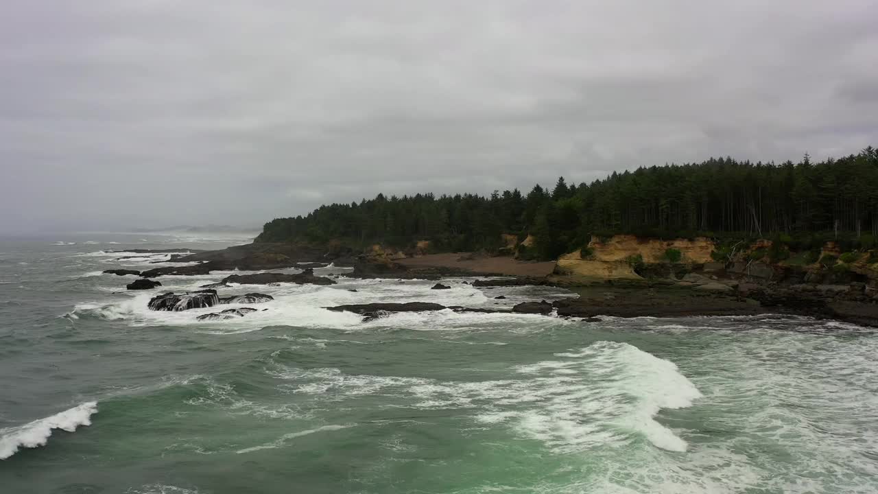 航拍的海浪拍打在海岸线上的岩石，无人机在海洋上空-曼萨尼塔，俄勒冈州视频素材