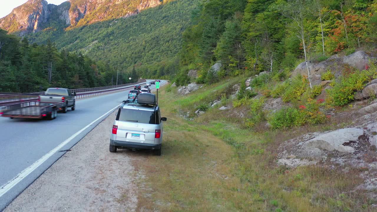 空中拍摄的车辆在道路上的树木在山在秋天-弗兰科尼亚，新罕布什尔州视频素材