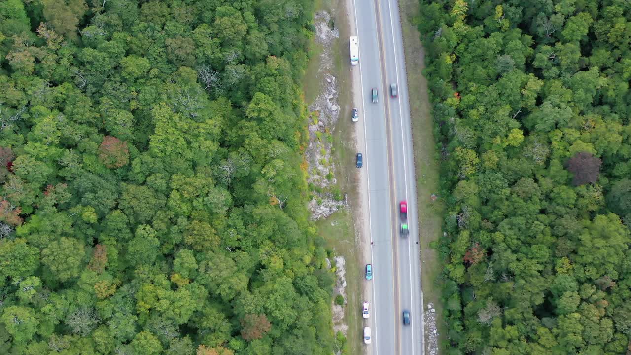 空中拍摄的车辆在道路上的秋天的树木，无人机下降-弗兰科尼亚，新罕布什尔州视频素材