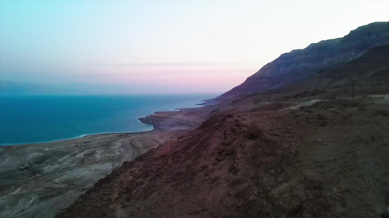 鸟瞰图美丽的山在死海对天空日落，车辆在道路上移动视频素材