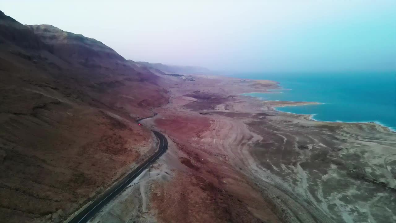 鸟瞰图美丽的山和死海在日落时的天空，无人机在风景上平移视频素材