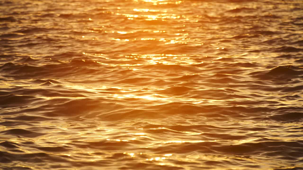 金色的海洋荡漾着波浪，海水作为大自然的背景4K视频视频素材