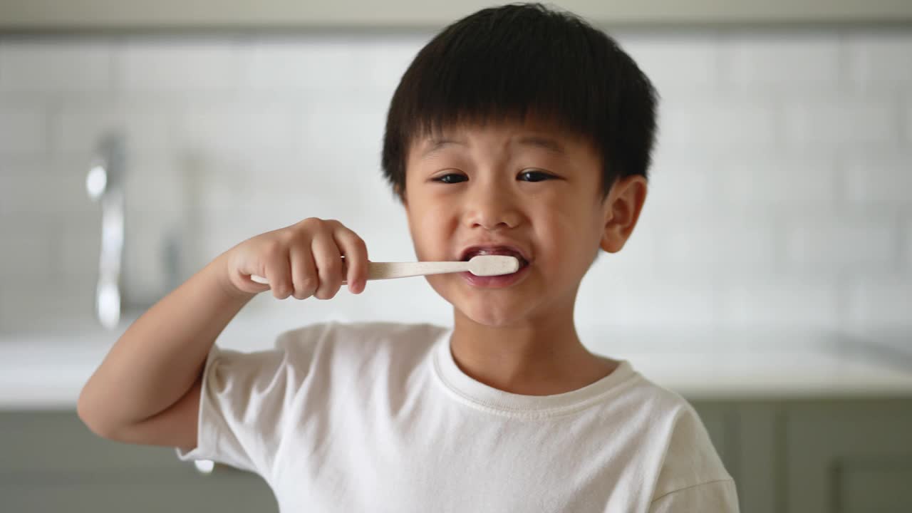 一个亚洲小孩在浴室里刷牙。日常健康和牙科护理的概念视频素材