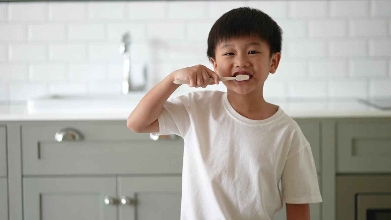 一个亚洲小孩在浴室里刷牙。日常健康和牙科护理的概念视频素材