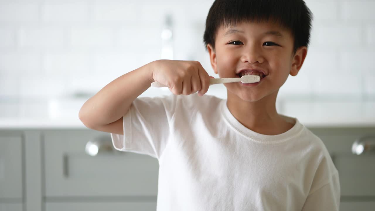 一个亚洲小孩在浴室里刷牙。日常健康和牙科护理的概念视频素材