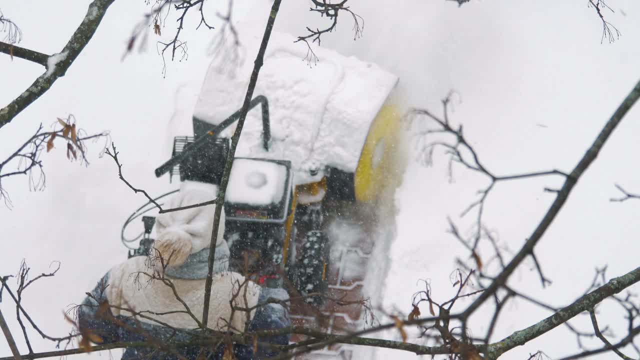 用手动除雪机清除人行道上的积雪，4k慢镜头60fps视频素材