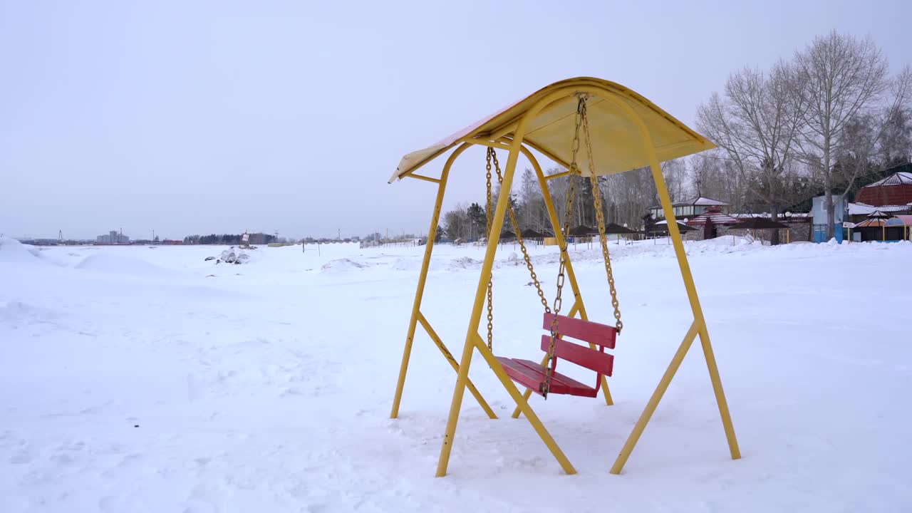 一个古老的秋千，映衬着白雪覆盖的海岸视频下载