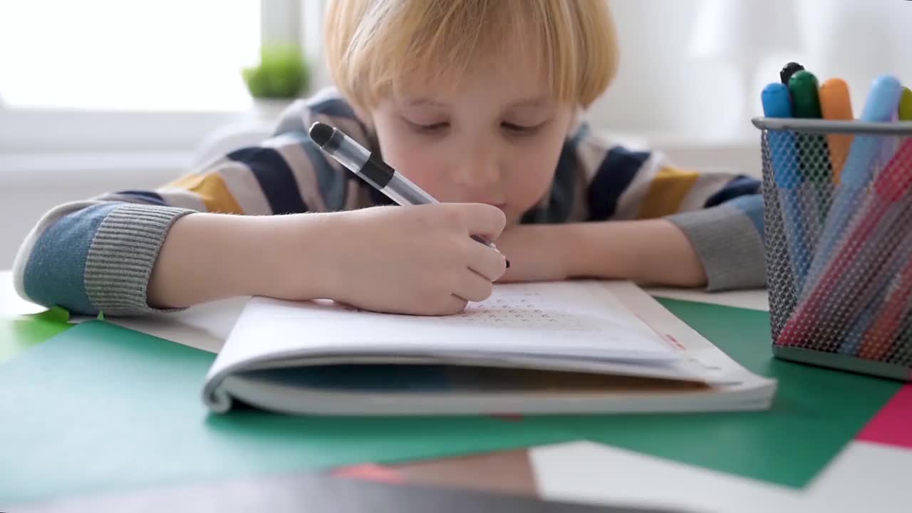 小学生在家里做作业。孩子学习数数，解决算术例子，做练习册上的练习。数学教程。为学龄前婴儿上学做准备。教育视频素材